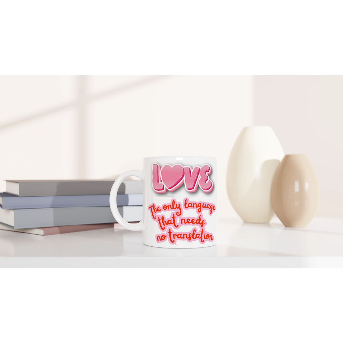 White ceramic mug on a counter with colorful text printed on it saying: LOVE, the only language that needs no translation. Front vue
