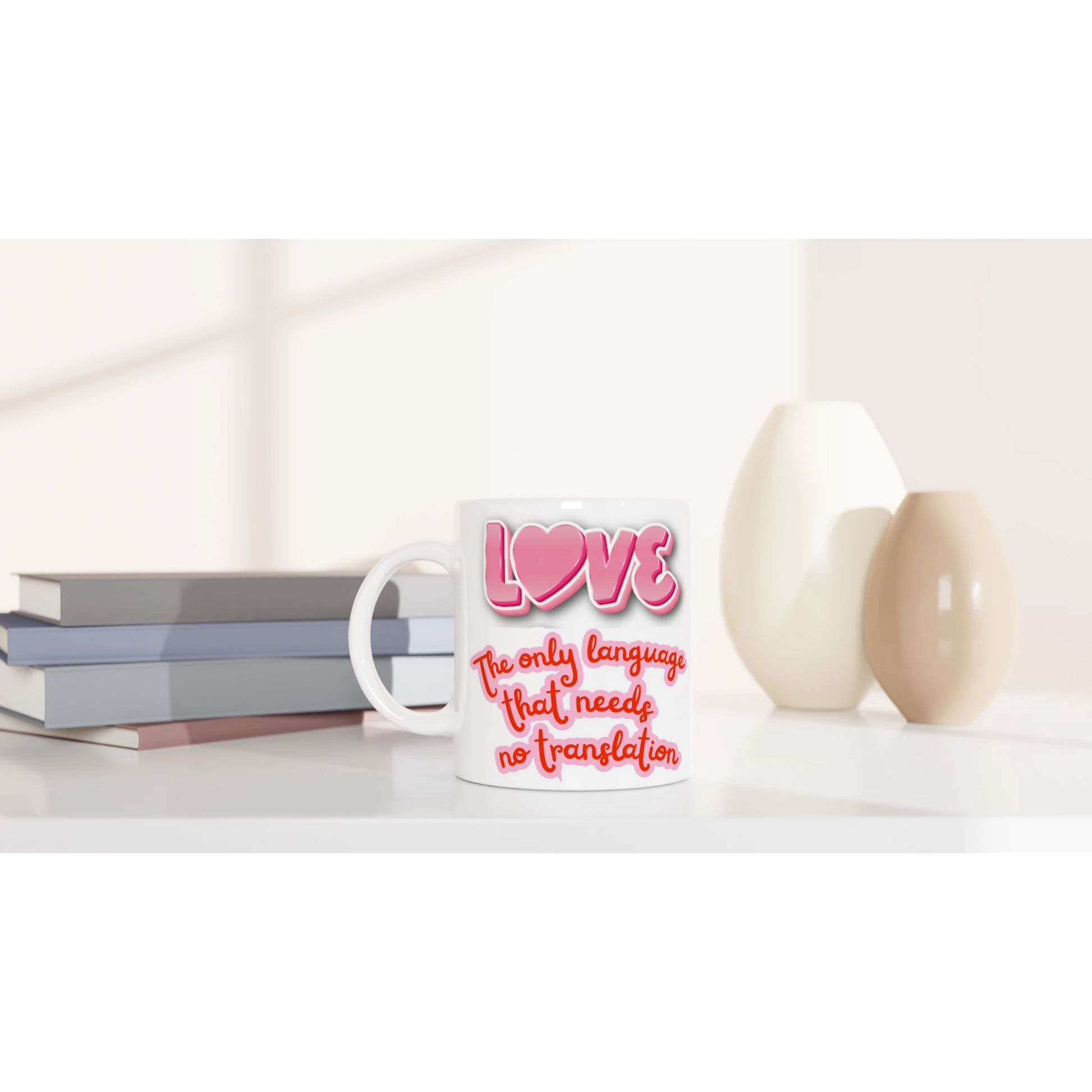 White ceramic mug on a counter with colorful text printed on it saying: LOVE, the only language that needs no translation. Front vue